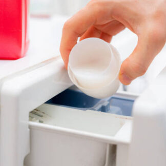 pouring the washing conditioner in the washing machine to get clean clothes