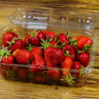 Fresh strawberry in plastic box on a wooden table