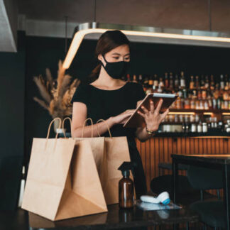 A cafe waitress preparing take out food orders for delivery